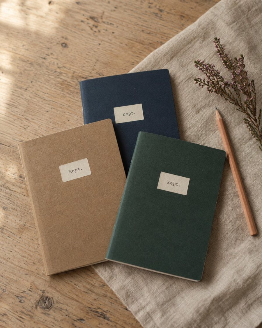 Three notebooks in kraft, navy and bottle green with kept. labels
